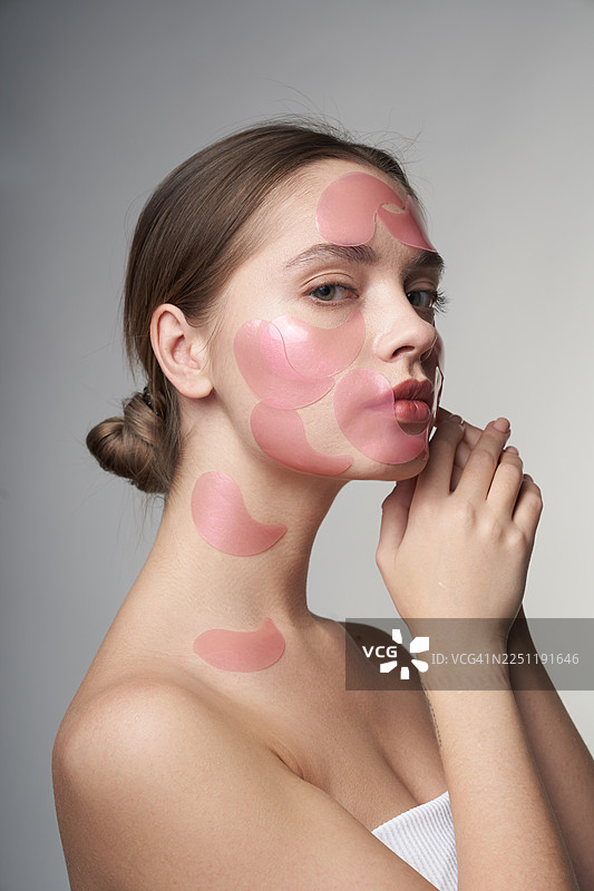 粉色水凝胶眼膜的女性肖像，展示护肤、美容和呵护。图片素材