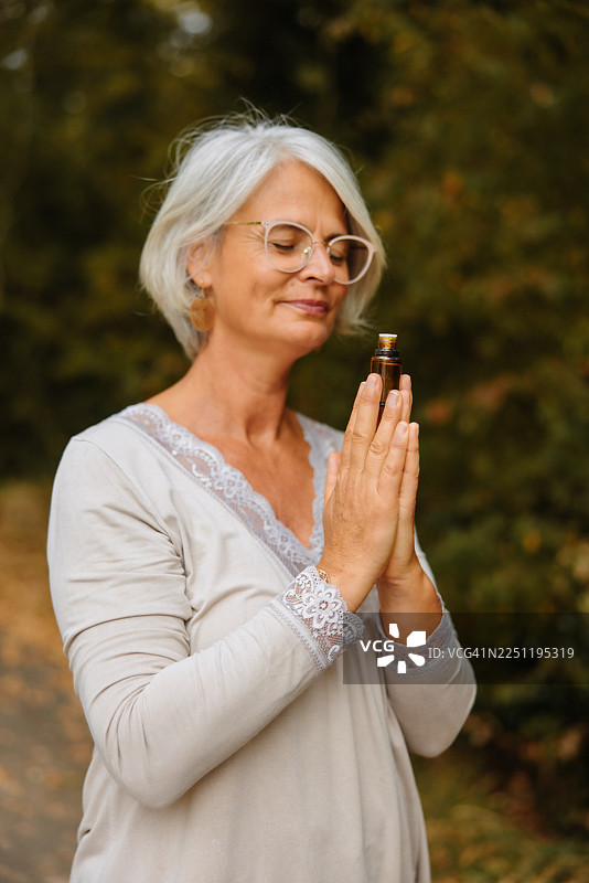 一位成熟的女性正在体验精油舒缓的香气图片素材