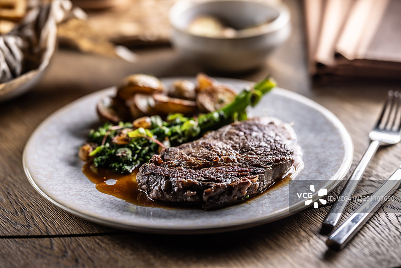 经典红酒汁煎牛排，配以烤土豆和西兰花或葱图片素材