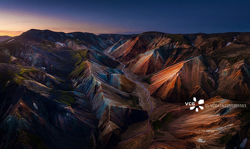 无人机在黄昏时分拍摄的冰岛兰德曼纳劳卡彩色流纹岩山脉景象。图片素材