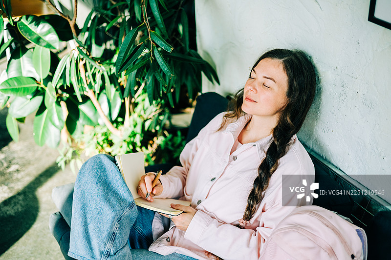 女人在沙发上放松地写日记图片素材