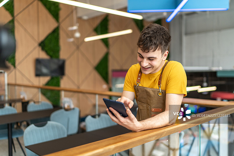 年轻的男员工在咖啡馆使用数码平板图片素材