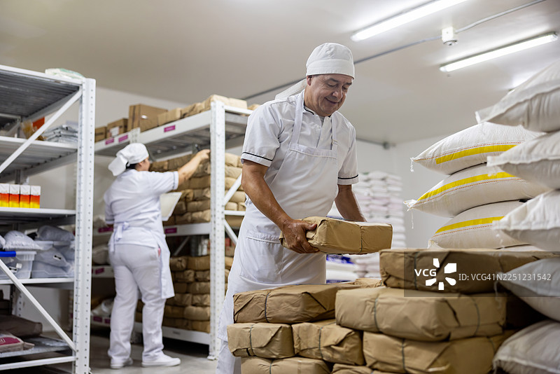 面包师在工业化面包房清点面粉库存图片素材