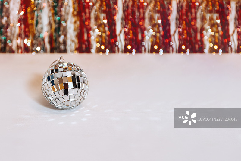 银色迪斯科球在圣诞魔法的彩色雨中闪耀，伴有发光粒子图片素材