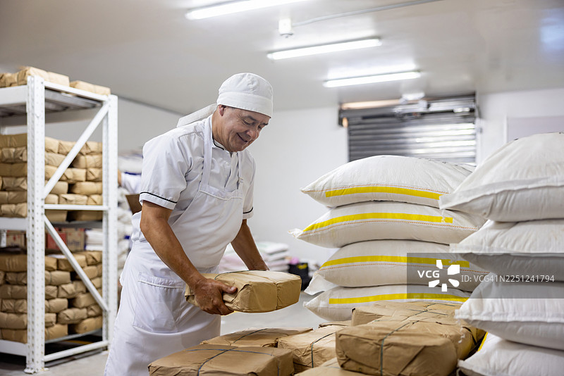 面包师在面包店整理面粉袋图片素材