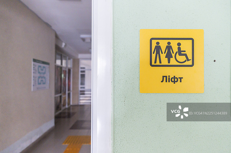 带盲文和无障碍符号的黄色电梯标志图片素材