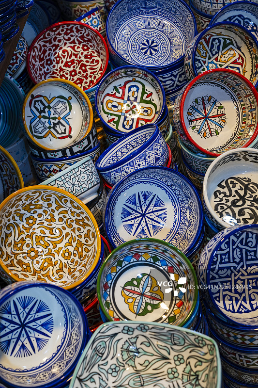 色彩鲜艳、图案复杂的陶瓷碗和盘子叠放在一起。摩洛哥北部内陆菲斯市菲斯-梅克内斯图片素材