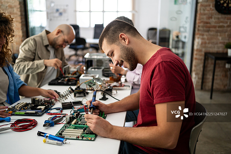 人们用电烙铁修理电脑电路板图片素材