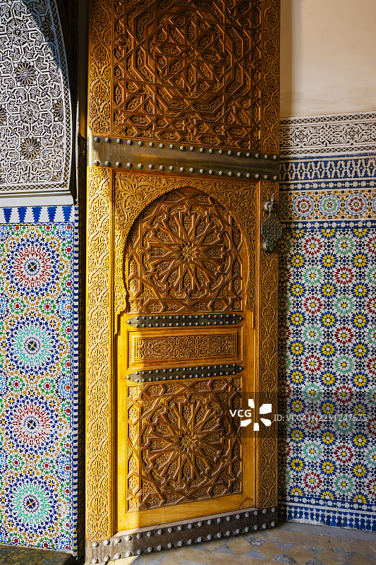 摩洛哥马拉喀什一座拥有精美雕刻和色彩丰富马赛克瓷砖的复杂木门，细节丰富。图片素材