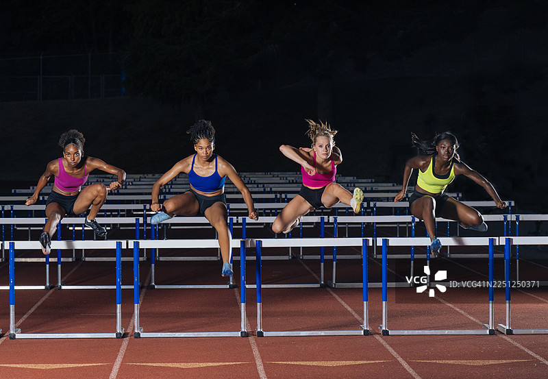 四名身着鲜艳运动服的运动员同步跳过田径栏架，地点位于美国华盛顿州。图片素材