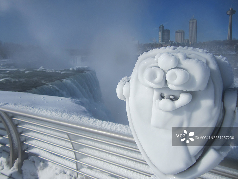 寒冷冬日，积雪覆盖的投币望远镜俯瞰美国尼亚加拉大瀑布图片素材