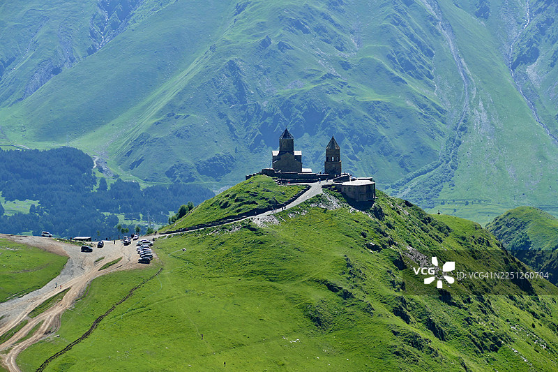 格鲁吉亚卡兹别吉，高加索山脉中海拔极高的格尔盖蒂三一教堂，俯瞰着壮丽的山谷和山峰景色图片素材
