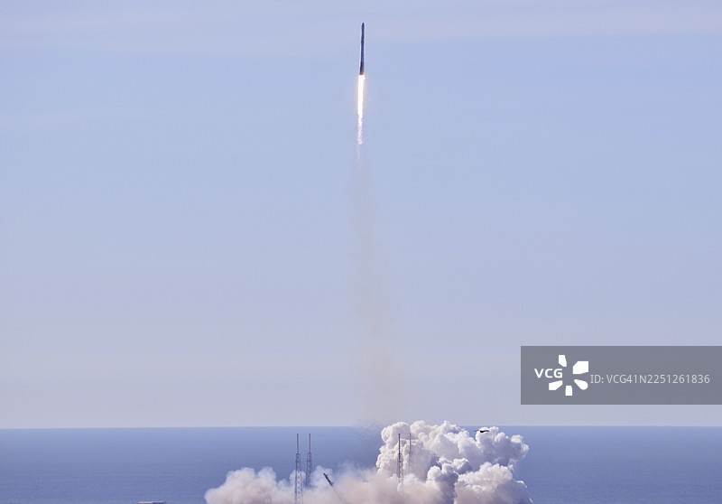 火箭在海上发射，浓烟滚滚，蓝天澄澈，象征着雄心与进步图片素材