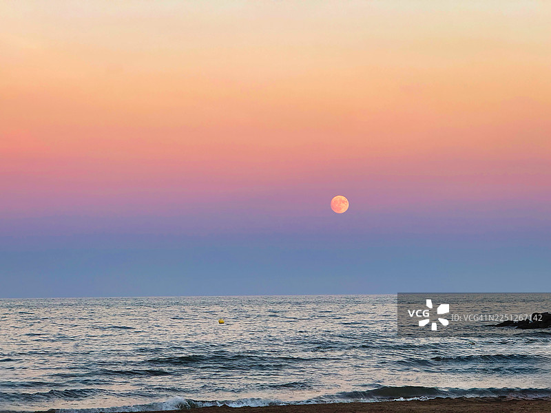西班牙阿尔沃拉亚，日落时分，一轮满月从海上升起，天空呈现出美丽的渐变色，Orxateria Toni图片素材