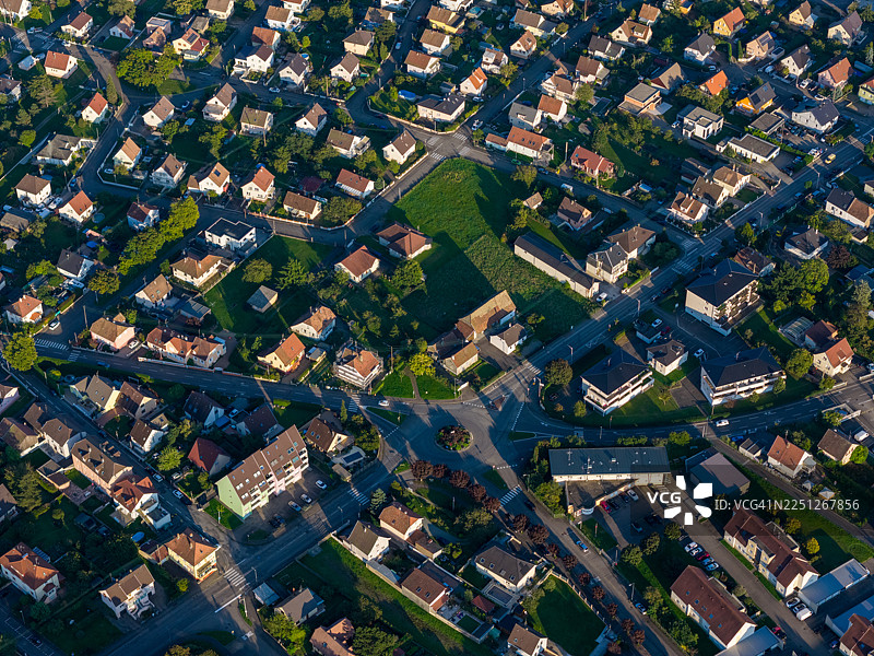 金色时段阳光下的密集居民区航拍图，包含房屋和街道图片素材