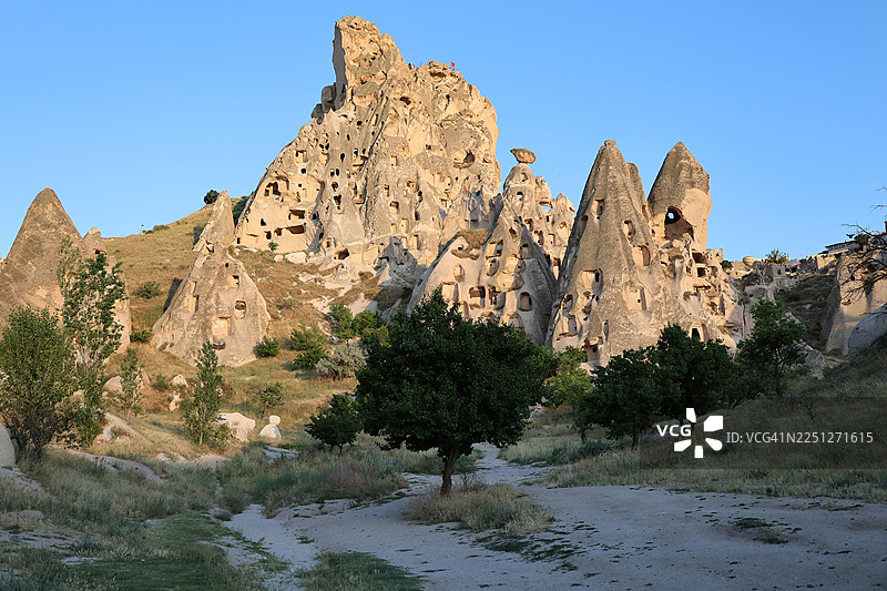 土耳其卡帕多奇亚，古老的洞穴民居雕刻在岩石构造中，背景是湛蓝的天空图片素材