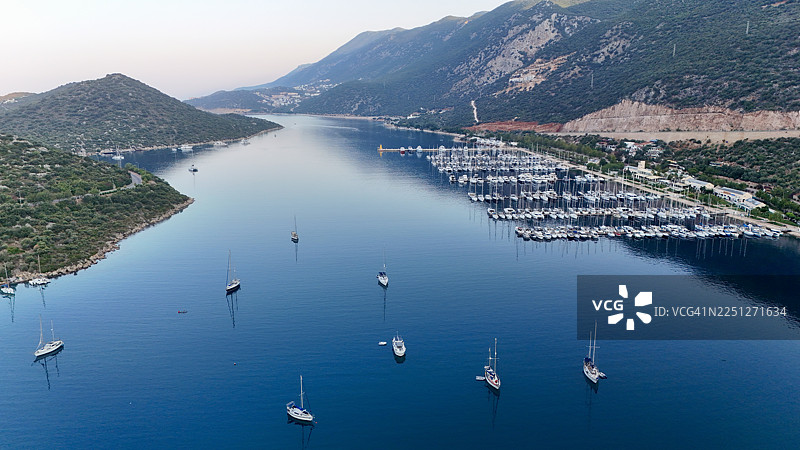黄昏时分，远眺群山环抱的宁静海湾，俯瞰停泊的船只和游艇。图片素材
