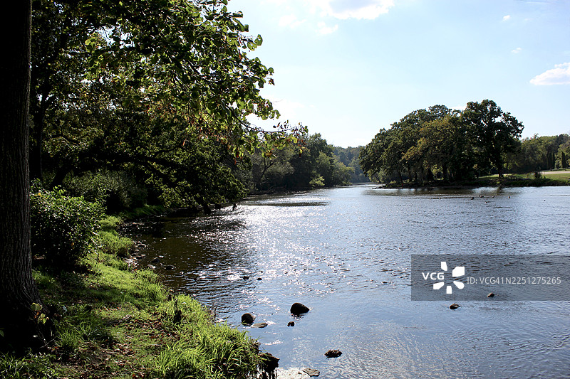 宁静的河流景色，碧绿的树木，波光粼粼的水面，蓝天映衬，非常适合自然与宁静主题，美国沃特福德图片素材