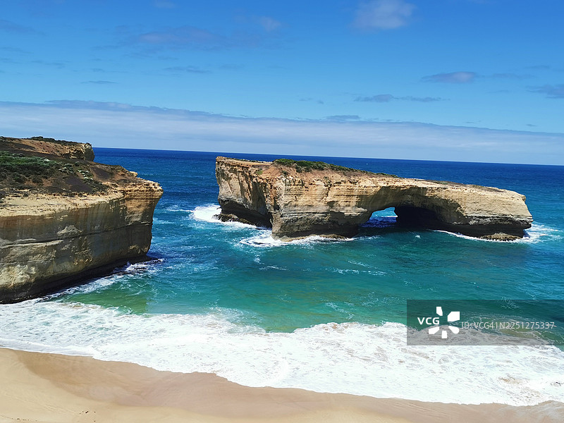 晴朗天空下，湛蓝大海中戏剧性的海岸风光，拥有岩石构造和天然拱门图片素材