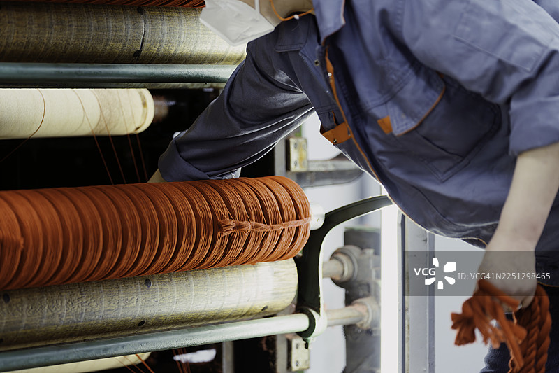 女纺织工人正在工厂里工作。图片素材