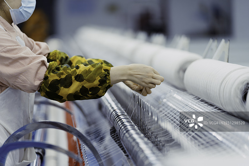 女纺织厂工人在工厂工作。图片素材