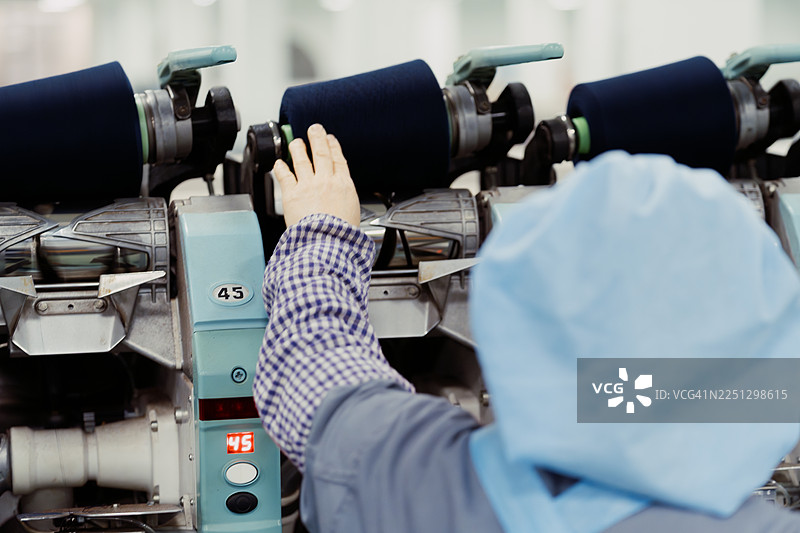 女纺织工人正在工厂工作。图片素材