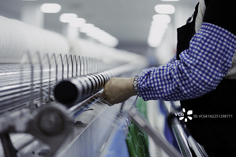 女纺织工人正在工厂工作。图片素材