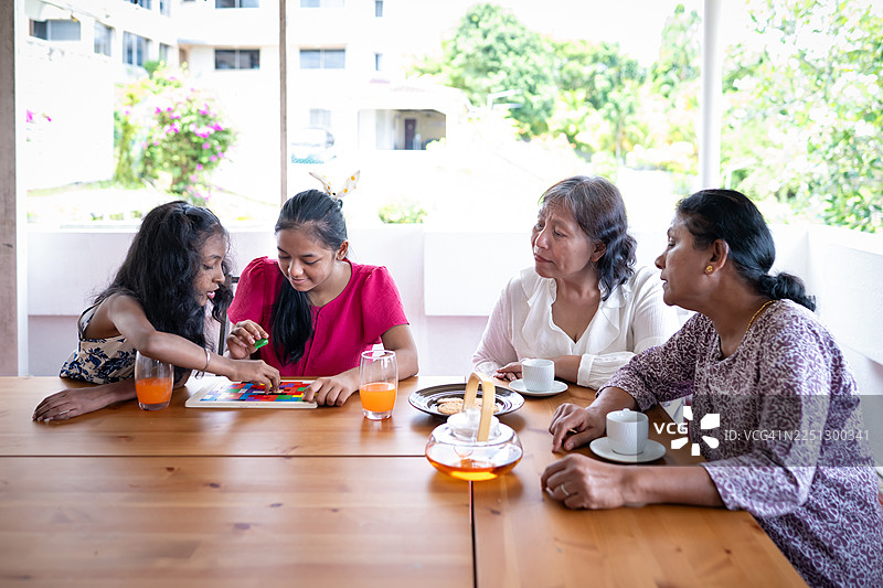 两位友爱的邻居享受茶歇和拼图时光图片素材