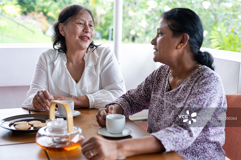 年长的印度女性和成熟的穆斯林女性在拜访时愉快地交谈图片素材