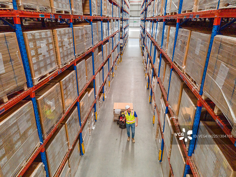 操作女工正在检查和检验堆叠的货物以备发货。工作人员正在检查工厂仓库。工业工厂仓库。工人在仓库扫描包裹。图片素材