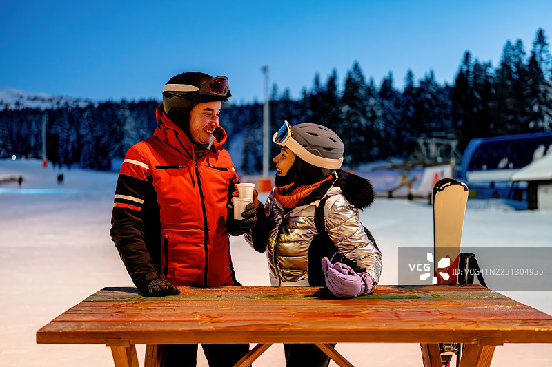 滑雪后，一对情侣在户外享用热饮，享受冬日时光图片素材