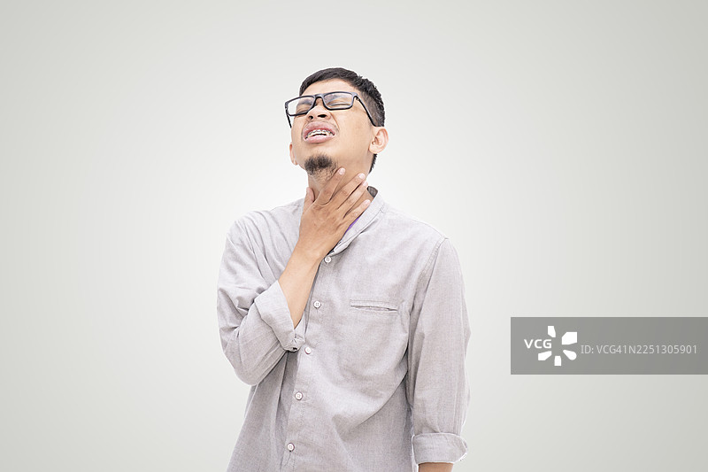 一名亚洲男子捂着喉咙，面露痛苦的表情，背景为白色图片素材