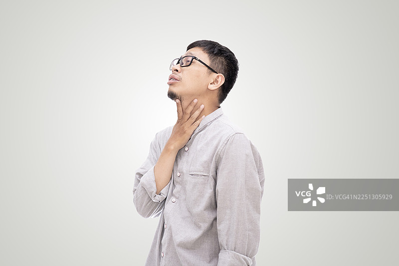 一个亚洲男人痛苦地捂着喉咙，背景为白色图片素材
