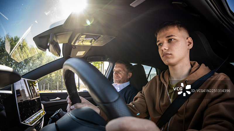 年轻学员在现代汽车内饰中与教练练习图片素材