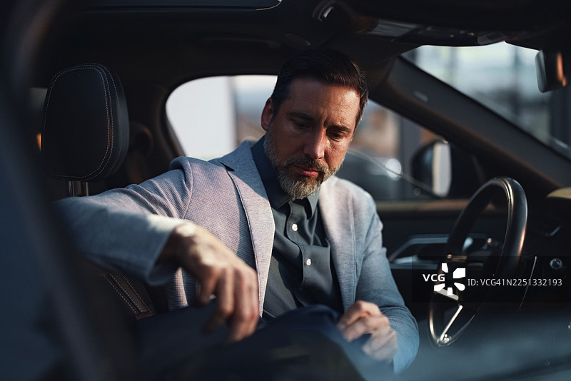 商务人士在车内深夜工作时整理包袋图片素材