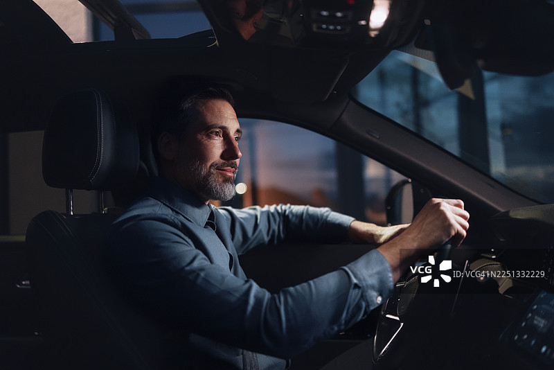 专业商务人士在夜间驾驶现代汽车进行公司出行图片素材