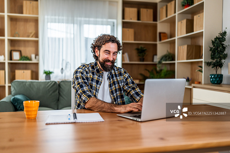 男士在家通过笔记本电脑远程办公图片素材