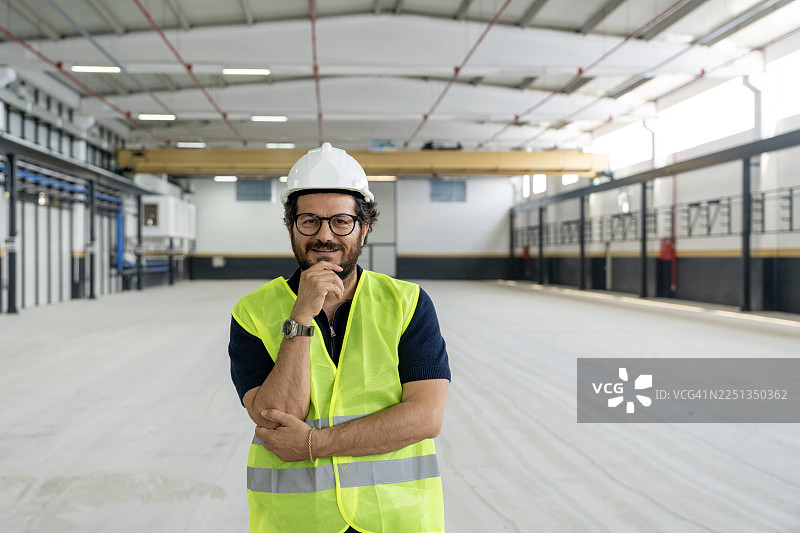 戴着安全帽、手托下巴的工程师在工厂现场图片素材