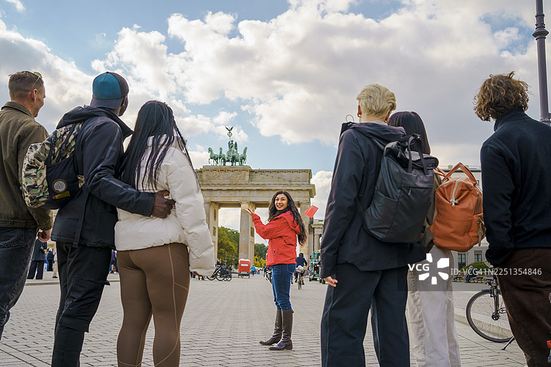 阴天，一名女导游在柏林勃兰登堡门前为游客朋友们讲解图片素材