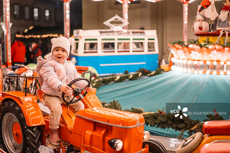欢乐的孩子在节日集市上骑着旋转木马拖拉机图片素材