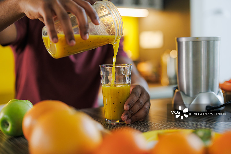 男人在家中倒新鲜果汁图片素材