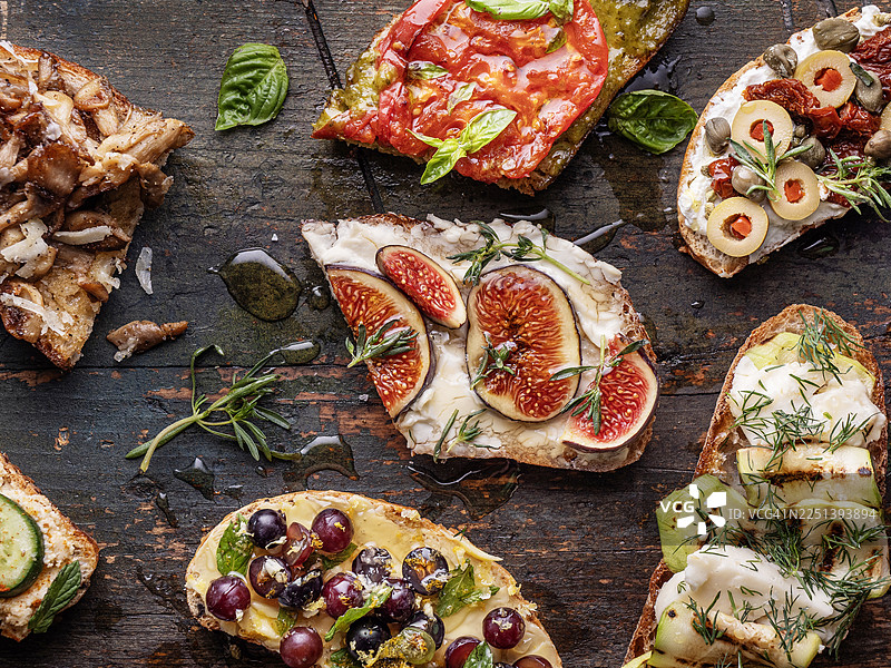 乡村深色木质背景上的各式烤面包片和小吃图片素材