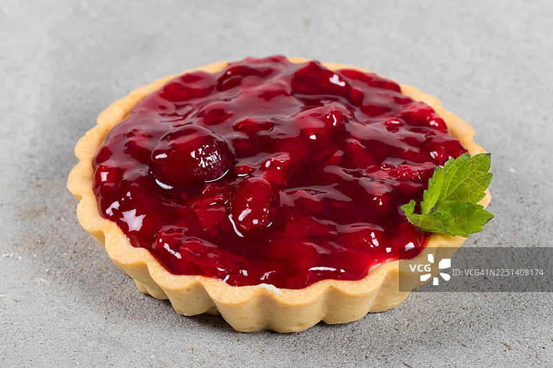 素食樱桃挞，带薄荷叶，浅灰色背景，特写图片素材