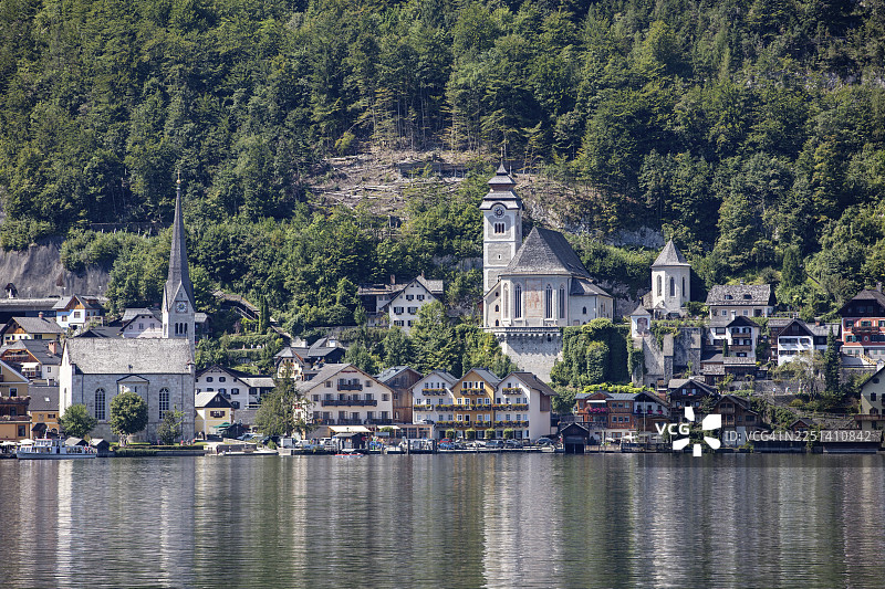 奥地利哈尔施塔特，风景如画的湖畔村庄，有教堂和森林覆盖的山峦背景图片素材