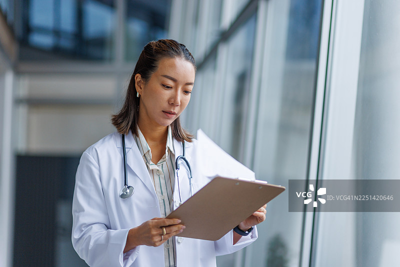 女医生在医院走廊查看病历图片素材