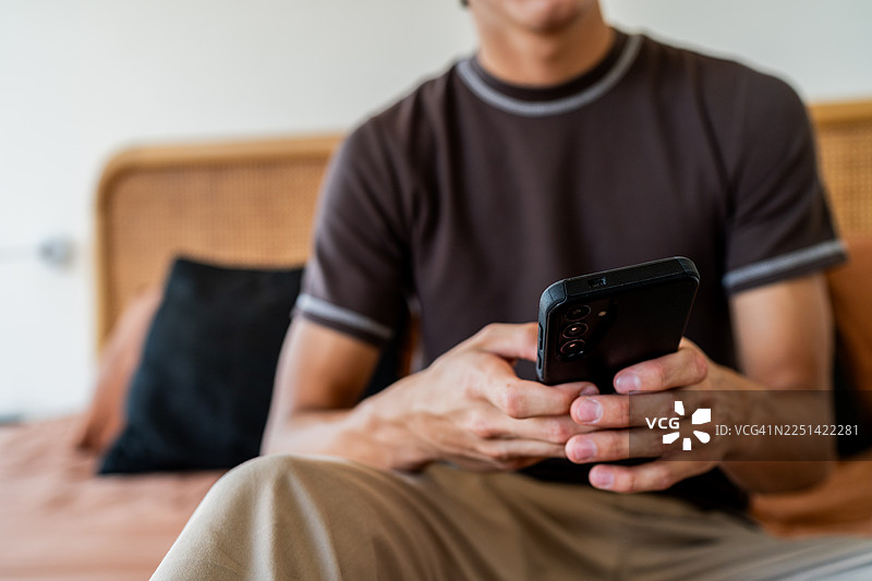 特写：一名少年在家中使用手机图片素材