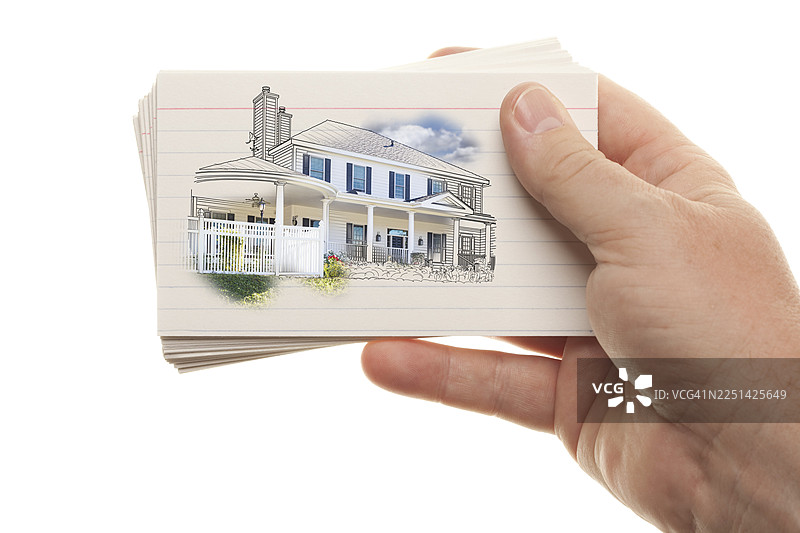 一只男人的手拿着一叠画着房子的闪卡，在白色背景下孤立。图片素材