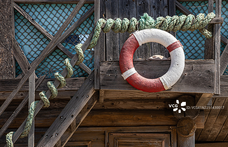 布满风霜的木质结构，配有救生圈和绳索，营造出航海和质朴的氛围图片素材