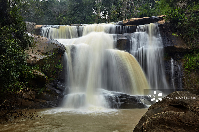 泰国茂密的绿色森林中雄伟的瀑布飞流直下图片素材