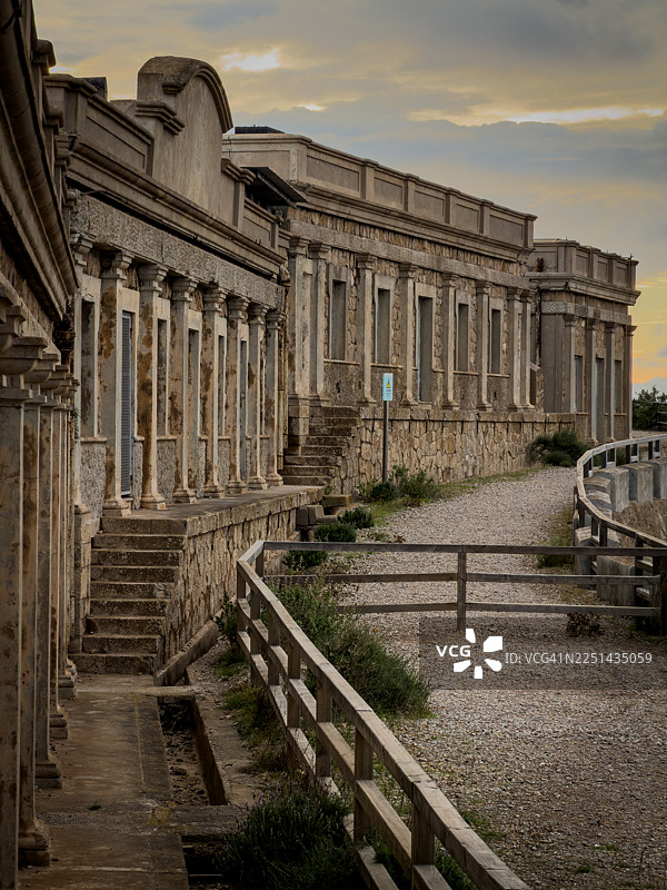 多云天空下的古老石建筑，带有柱子和楼梯，位于西班牙卡塔赫纳图片素材